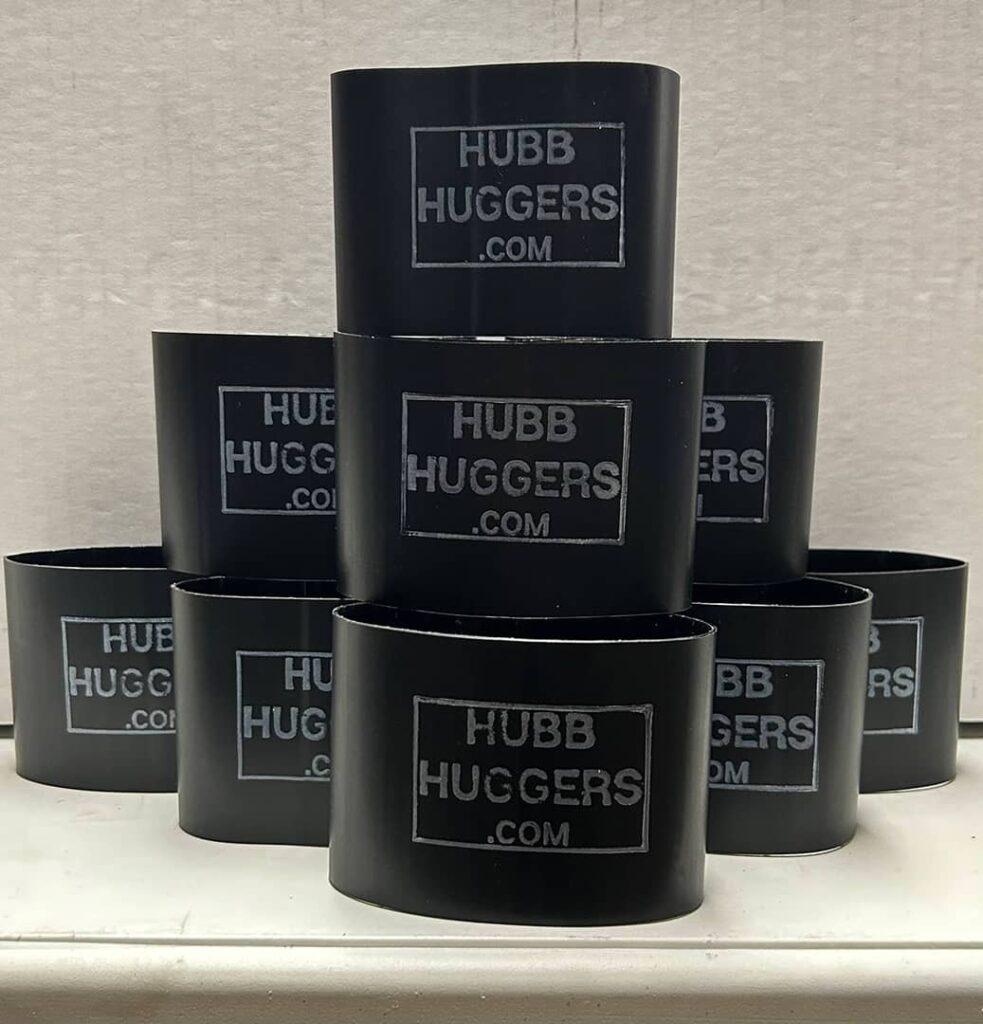 Stack of black Hubb Huggers 3 Inch in a 10 pack, displayed on a shelf, with white branding text 'HUBB HUGGERS .COM' visible on each.